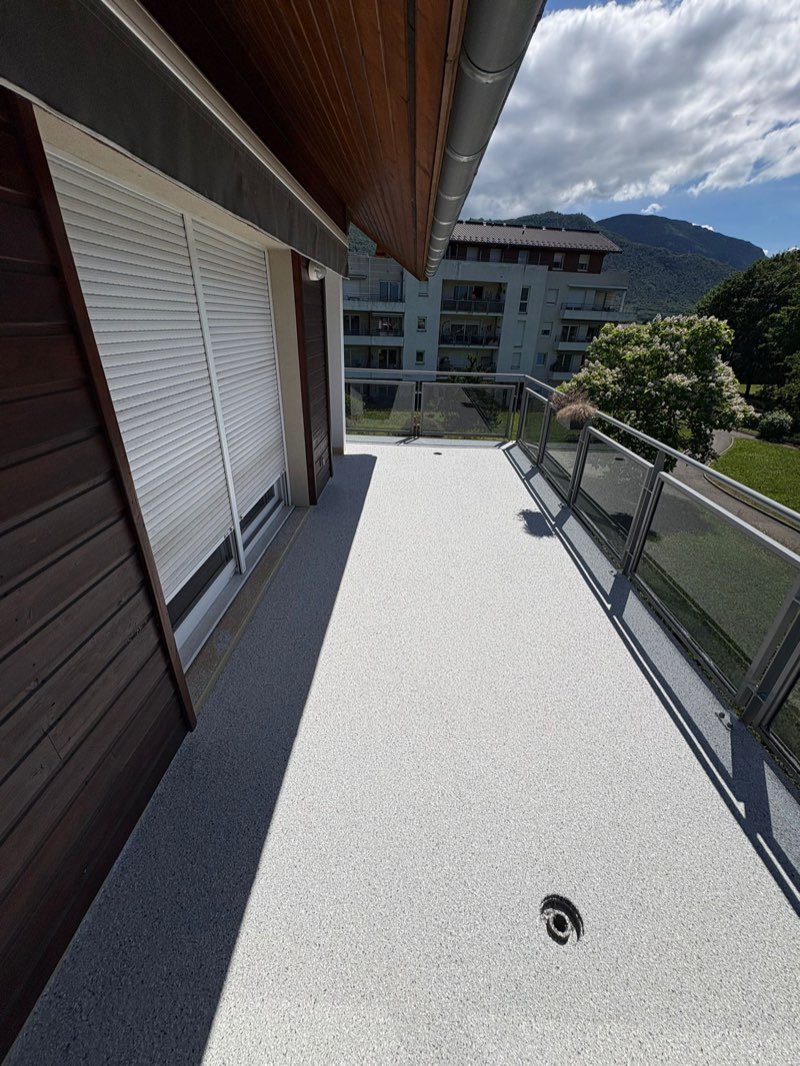 Balcon en résine quartz gris clair, garde-corps vitré face aux montagnes