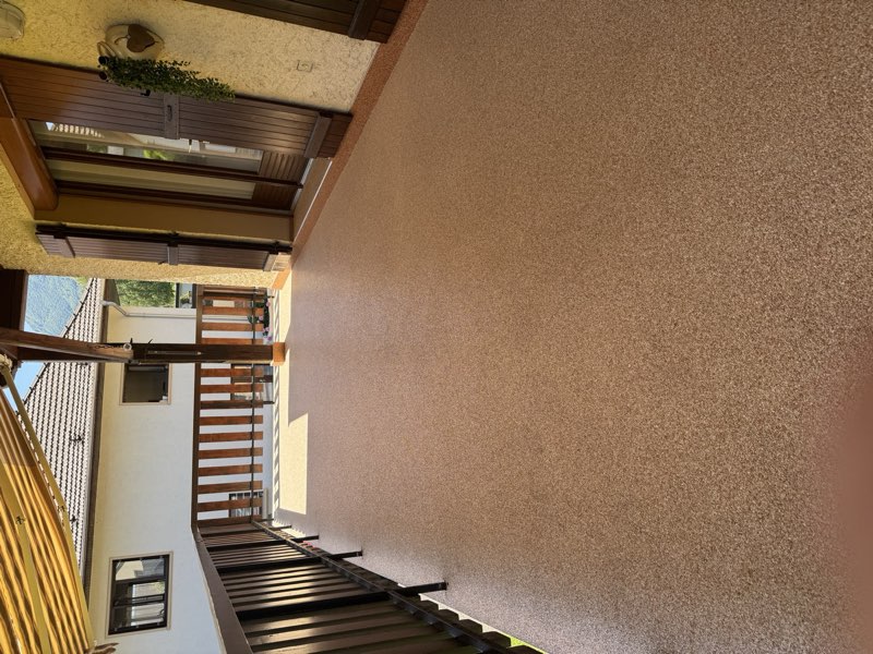 Terrasse en moquette de pierre beige avec garde-corps en bois