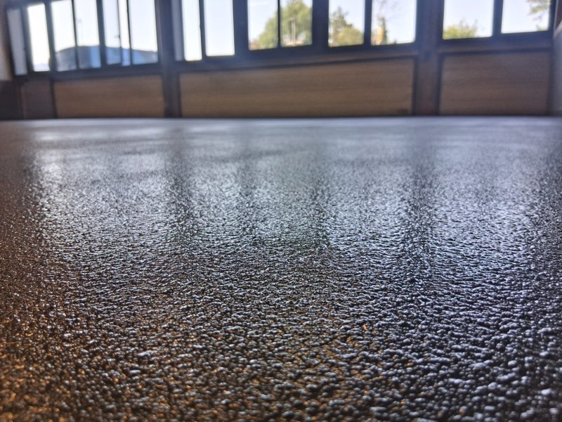 Détail de la texture granuleuse d'un sol en résine brun bronze